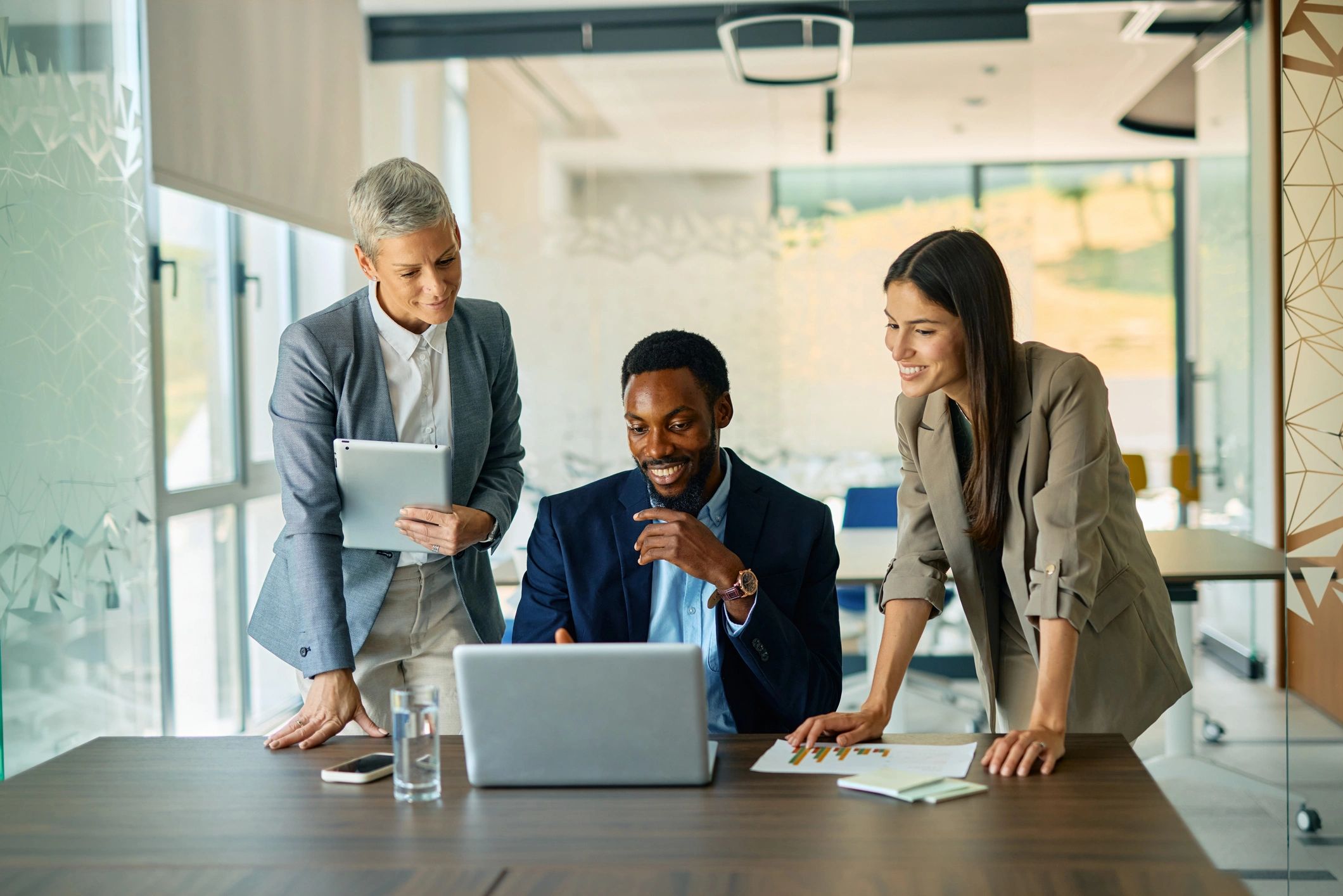 Technology team collaborating around a laptop in a modern office
